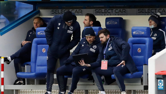 Coaches reviewing data on the bench